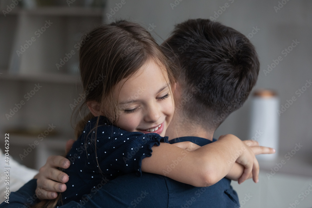 Little girl tightly cuddling her beloved daddy, close up. Young dad enjoy moment of tenderness and caress embracing his adorable daughter. Happy Father Day congratulations and family bonding concept Little girl tightly cuddling her beloved daddy, close up. Young dad enjoy moment of tenderness and caress embracing his adorable daughter. Happy Father Day congratulations and family bonding concept