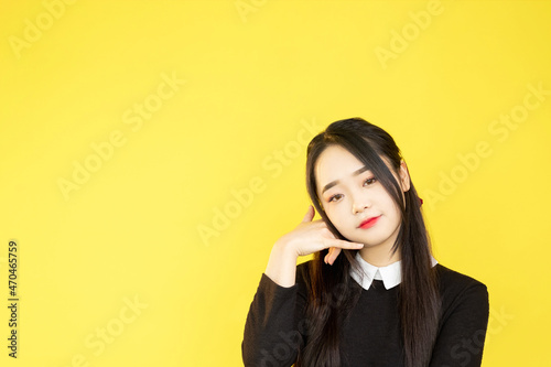 Call me gesture. Phone contact. Mobile connection. Advertising background. Cute beautiful woman showing telephone hand sign on yellow promo copy space.