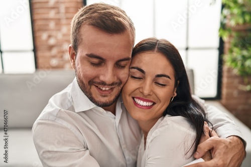 Man and woman couple smiling happy hugging each other at home