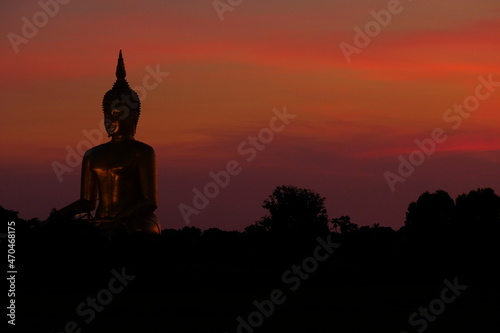 Big Buddha statue in shadow and red sky