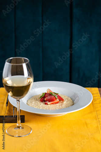 glass of wine and risotto with strawberries in the restaurant