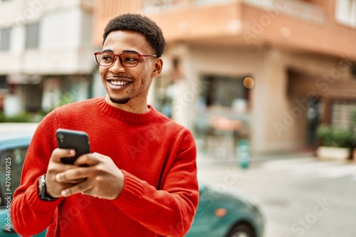Schilderij op canvas Handsome african american man outdoors using smartphone typing a message