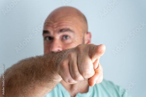Fotografie Close-up of a bald, bearded, caucasian man face, gesturing and accusing with the index finger