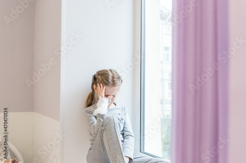 sad girl, patient in bed, in hospital with saline intravenous. Baby admitted at hospital. Medical check up and treatment concept. Sick child with fever and illness in bed.