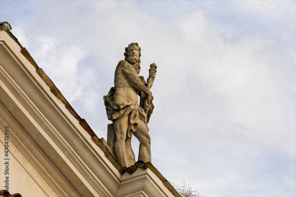Fototapeta premium Statua, scultura sopra il tetto di un edificio.