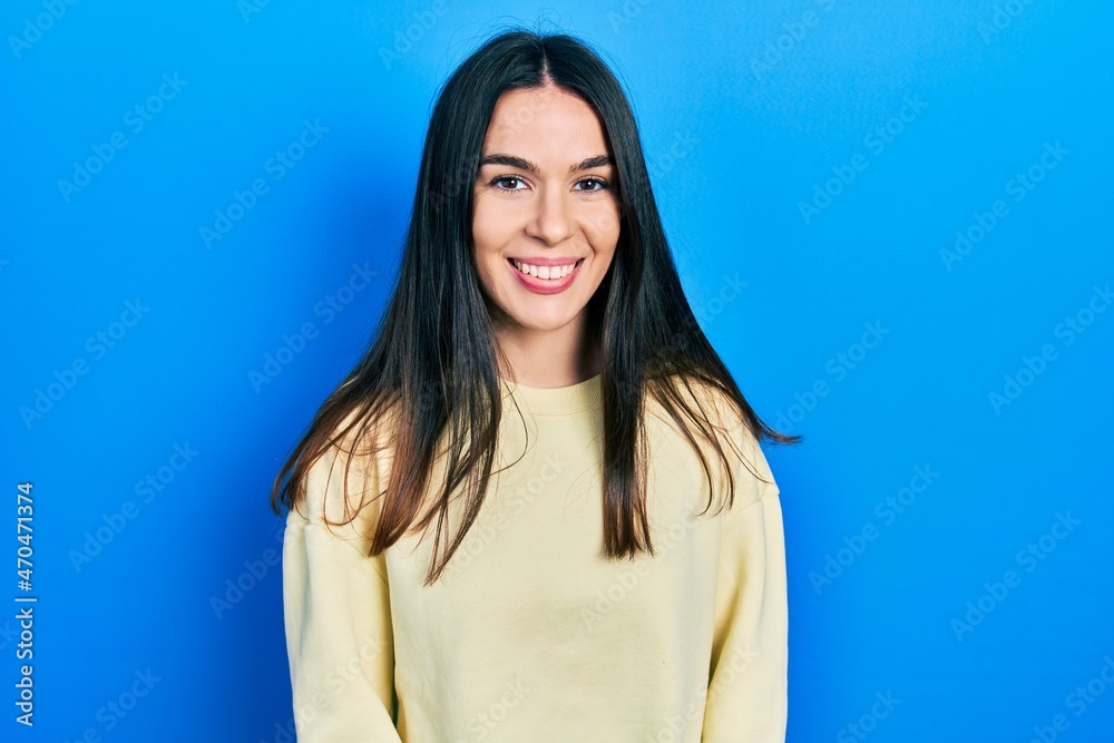 Fototapeta premium Young brunette woman wearing casual sweatshirt with a happy and cool smile on face. lucky person.