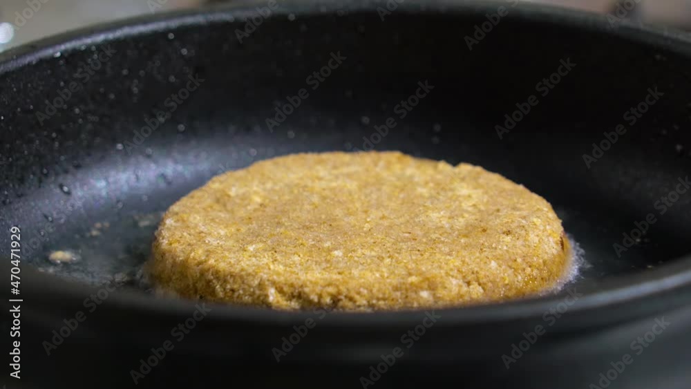Raw cutlet is placed in a pan with boiling oil, selective focus. Hot tasty juicy fried hamburger Patty with a crispy brown crust, lying on a pan with greasy olive oil. Fried beef cutlet meat cooked. Raw cutlet is placed in a pan with boiling oil, selective focus. Hot tasty juicy fried hamburger Patty with a crispy brown crust, lying on a pan with greasy olive oil. Fried beef cutlet meat cooked.