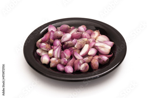Onions on a black plate on a white background