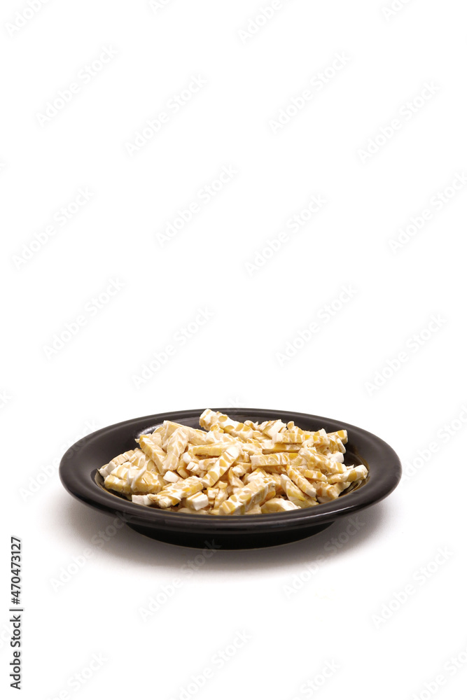 fermented soybeans that have been cut into small pieces on a black plate fermented soybeans that have been cut into small pieces on a black plate