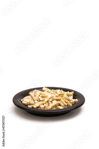 fermented soybeans that have been cut into small pieces on a black plate