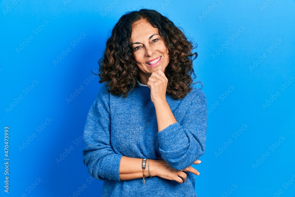 Middle age hispanic woman wearing casual clothes looking confident at the camera with smile with crossed arms and hand raised on chin. thinking positive. Middle age hispanic woman wearing casual clothes looking confident at the camera with smile with crossed arms and hand raised on chin. thinking positive.