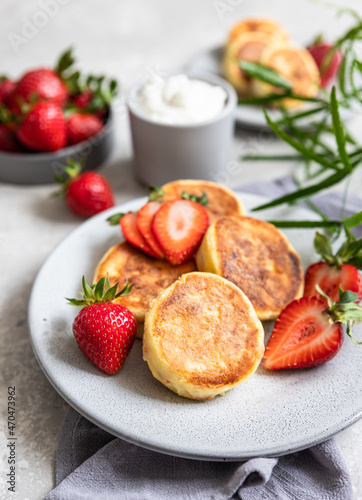 Cottage cheese pancakes or fritters with strawberry and natural yogurt. Healthy breakfast or lunch. Syrniki.