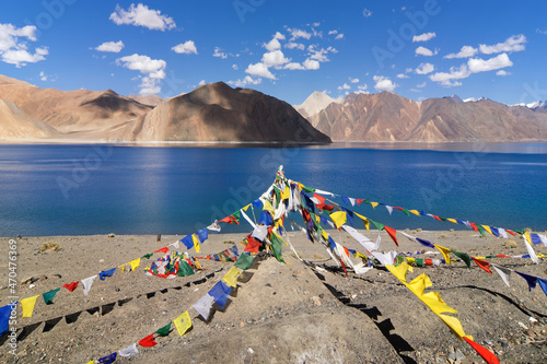 Buddhist prayer flags flying at Pangong tso (Lake). It is huge lake in the Himalayas shared by China and India along India China LOC border long and extends from India to Tibet.