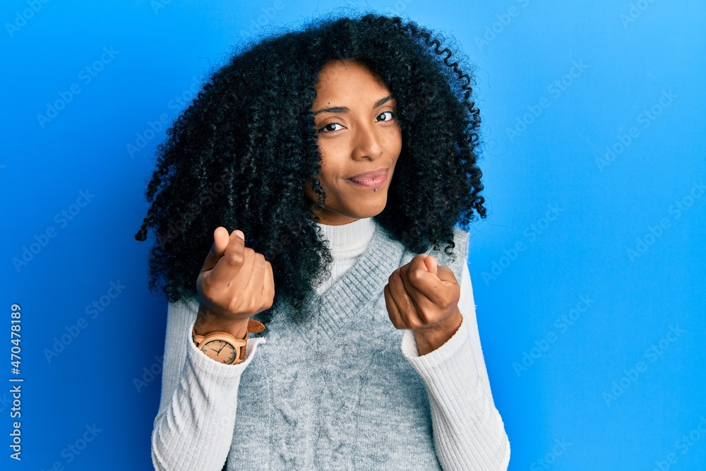 African american woman with afro hair wearing casual winter sweater doing money gesture with hands, asking for salary payment, millionaire business African american woman with afro hair wearing casual winter sweater doing money gesture with hands, asking for salary payment, millionaire business
