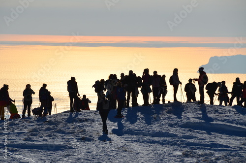 Raduno al tramonto sulla neve con sfondo il mare photo