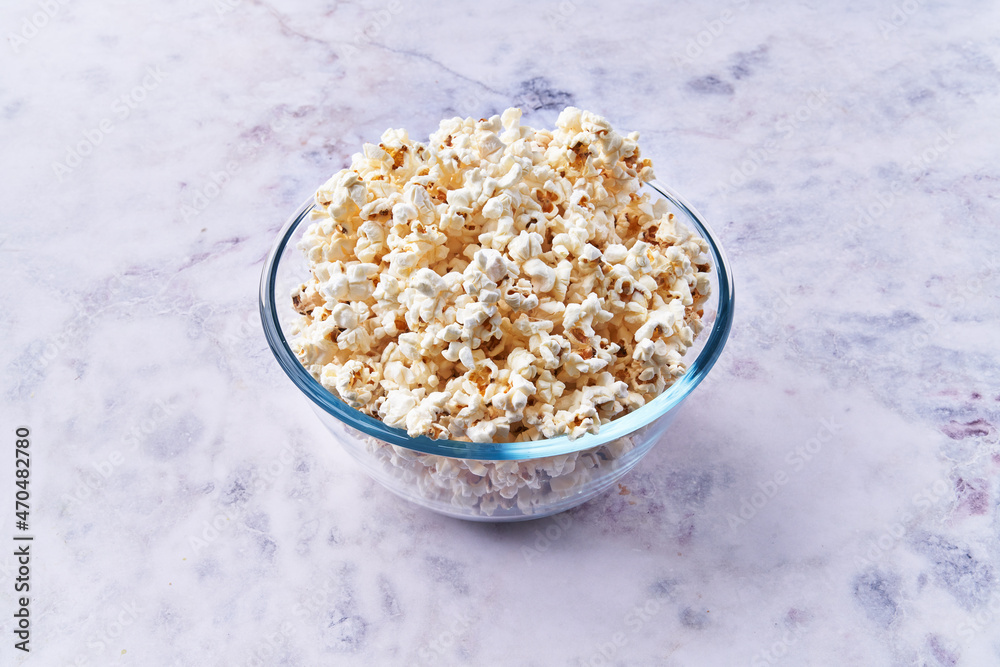 Bowl of salty popcorns on a marble surface Bowl of salty popcorns on a marble surface