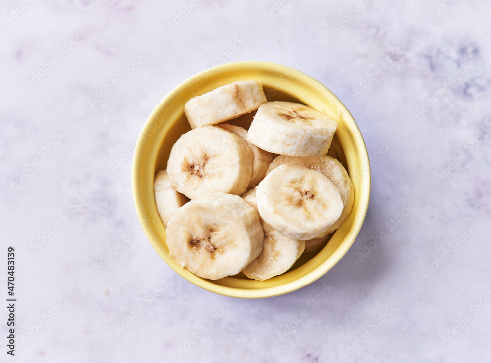 Bowl of slices of banana on a marble table Bowl of slices of banana on a marble table