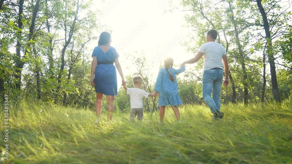 happy family. people walking together in the park silhouette. family kid dream concept. happy family walking holding hands in the park on the grass at sunset. friendly family sunlight dream together happy family. people walking together in the park silhouette. family kid dream concept. happy family walking holding hands in the park on the grass at sunset. friendly family sunlight dream together