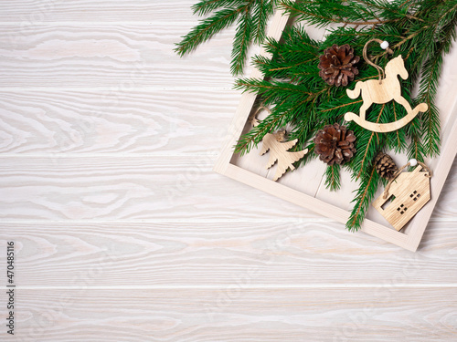 Christmas tree handmade toys and fir in white tray on wooden background, top view. Holiday sustainable eco diy decor and preparation flatlay. Rustic winter concept with copy space, place for text.