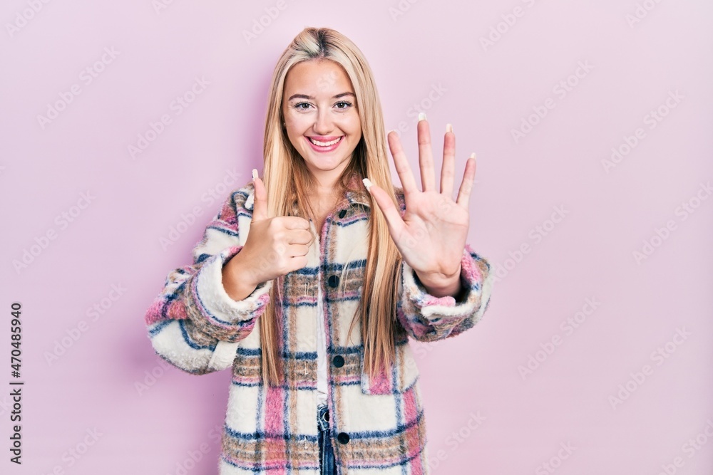 Young blonde girl wearing casual clothes showing and pointing up with fingers number six while smiling confident and happy. Young blonde girl wearing casual clothes showing and pointing up with fingers number six while smiling confident and happy.