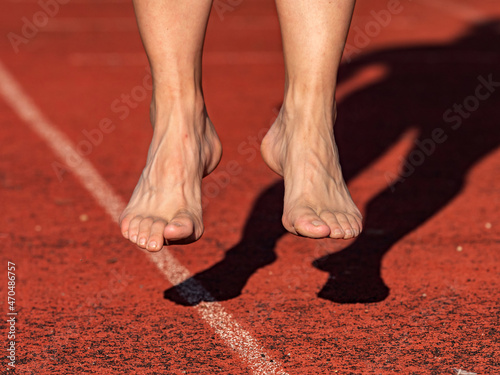 Middle aged barefoot jumping woman warm up calf muscles