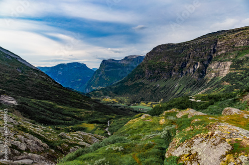 View from the road on a the valley between beautiful Norwegian mountains against dramatic cloudy sky