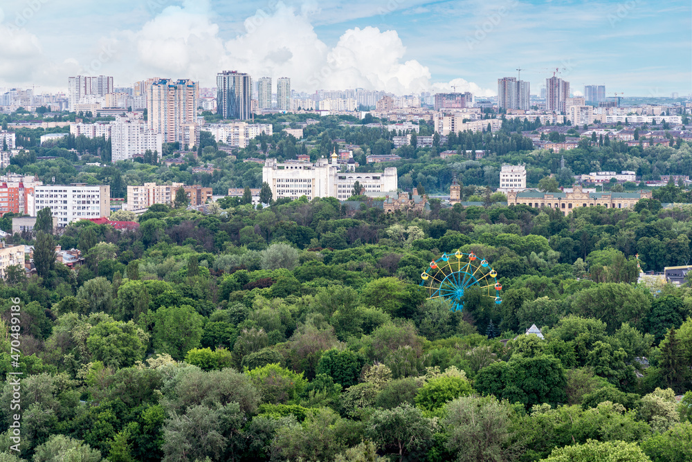 Kyiv cityscape with green area and old ferris wheel on foreground