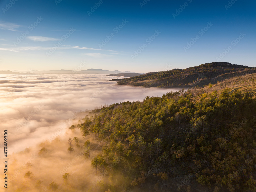 Italy November 2021: aerial view of mountains with fog below in autumn season at sunset