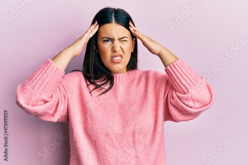 Beautiful brunette woman wearing casual winter sweater suffering from headache desperate and stressed because pain and migraine. hands on head. © Krakenimages.com