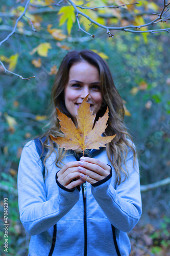 beautiful young woman holding a leaf