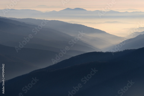 mountain ranges and slopes covered with forest in fog