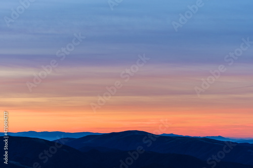 Beautiful orange sky over mountain range at sunset © vasmbphoto