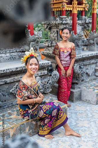 Portrait of two young balinese girls with traditional costume with offering in bali temple, indonesia © Ace Mason