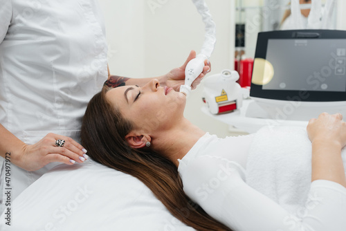 Rejuvenating facial skin treatment, correction of wrinkles. A young woman is given a massage with lifting therapy at a beauty spa. Exfoliation, Rejuvenation And Hydration. Cosmetology.  photo