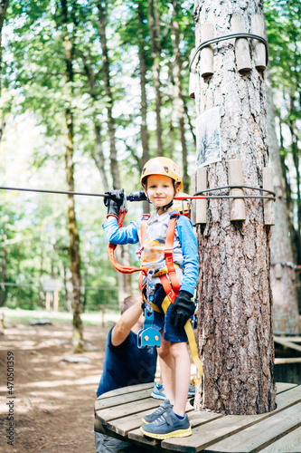 Boy in a helmet with safety equipment stands on a wooden platform