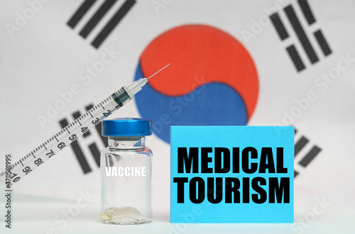 Vaccine, syringe and blue plate with the inscription - MEDICAL TOURISM. In the background the flag of South Korea