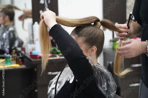 Work in a hairdressing salon. High tail. Measurement with fingers by hairdresser before start.