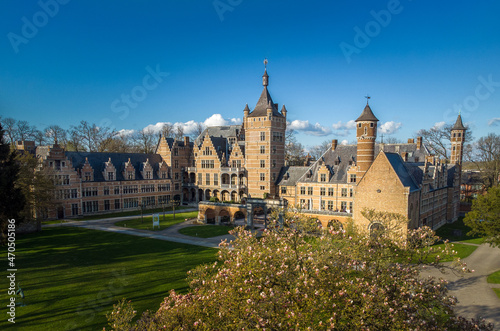 Castle Cantecroy in Mortsel Antwerp behind a treetop and blue sky in the background. Drone aerial view photo at a beautiful sunny day in spring