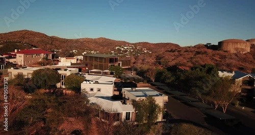 4K aerial Windhoek capital residential central hilly district bright sunset drone video, blooming Jacaranda trees, upmarket houses, old white walls German mansions in Khomas Region, central Namibia photo