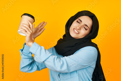 woman in black hijab a glass of coffee a warming drink isolated background