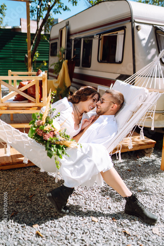 Happy newlyweds elaxing in rv, camping in a trailer. Couple embracing each other and smiling. Romantic moment. Together. Wedding. Marriage. photo