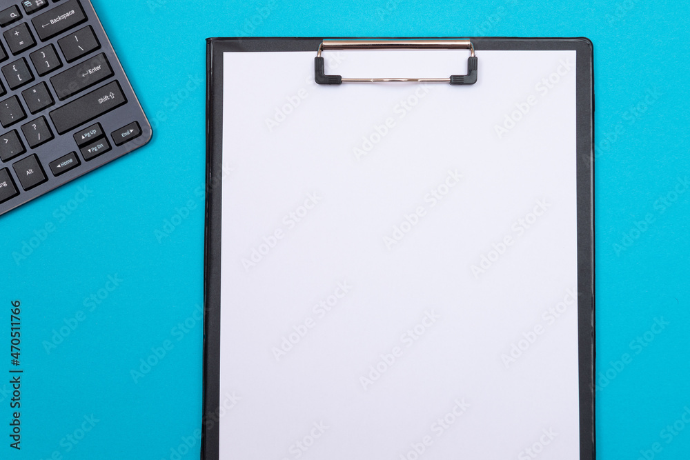 Black Clipboard with Blank White Sheet of Paper Lying on Blue Table - Top View, Flat Lay Black Clipboard with Blank White Sheet of Paper Lying on Blue Table - Top View, Flat Lay