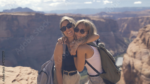 Happy people celebrating cheering in Grand Canyon. Young multiethnic couple on hiking travel excited and elated in Grand Canyon, south rim, Arizona, USA. Asian woman and Caucasian man.