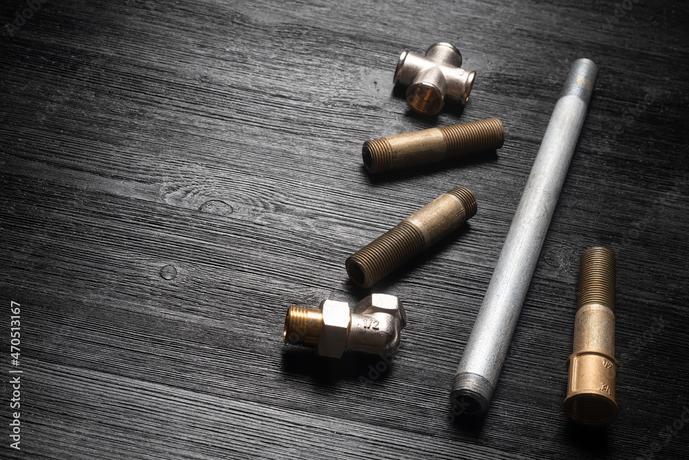 Water pipes on the black workbench background with copy space. Plumbing.