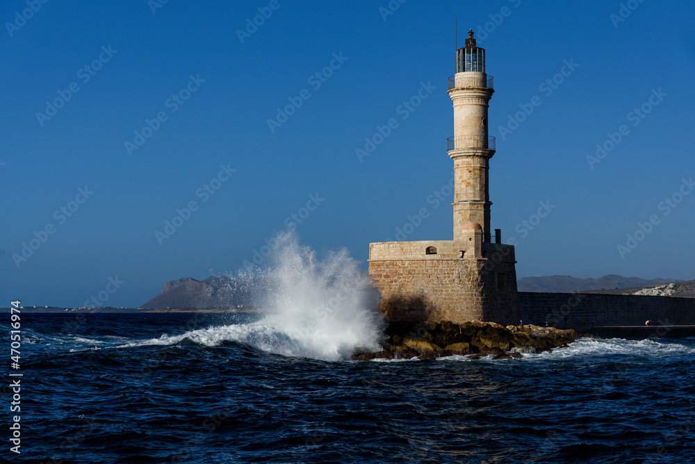 waves crash against the Venetian lighthouse in Chania