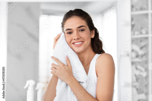 Woman Drying Face With Towel Standing After Shower In Bathroom