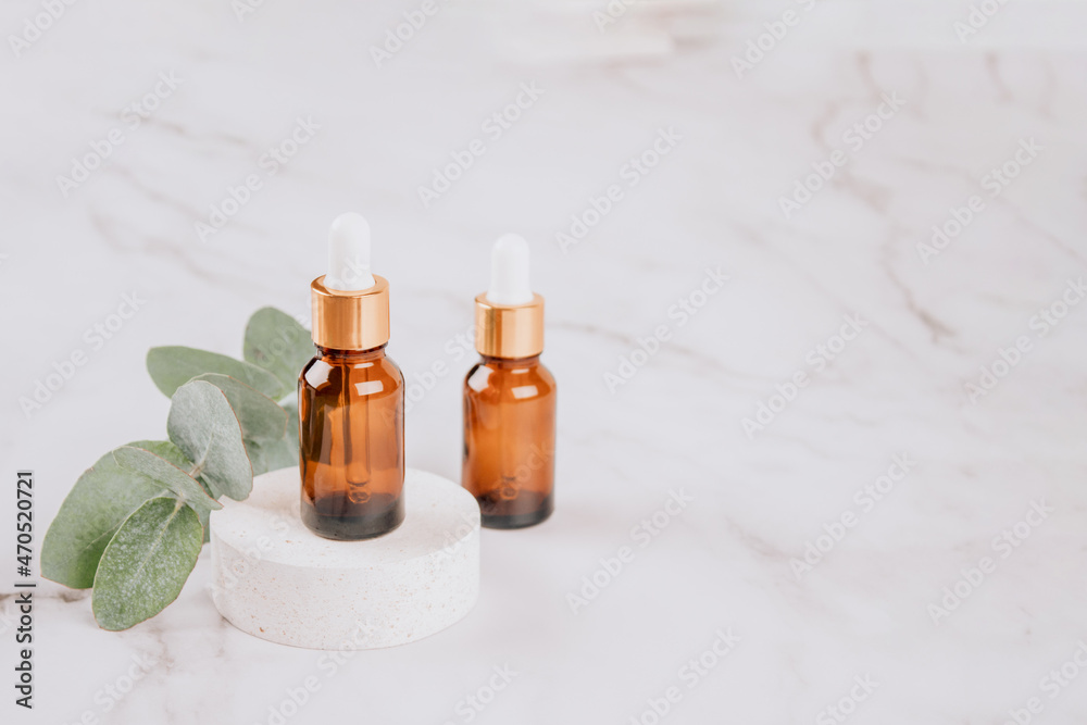 Glass dropper bottles with eucalyptus oil on marble table background with copy space. Modern organic cosmetics or aromatherapy concept, facial skincare. Mockup image, modern apothecary concept Glass dropper bottles with eucalyptus oil on marble table background with copy space. Modern organic cosmetics or aromatherapy concept, facial skincare. Mockup image, modern apothecary concept