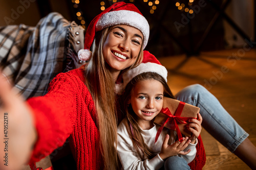 Portrait of happy woman and daughter talking selfie at xmas