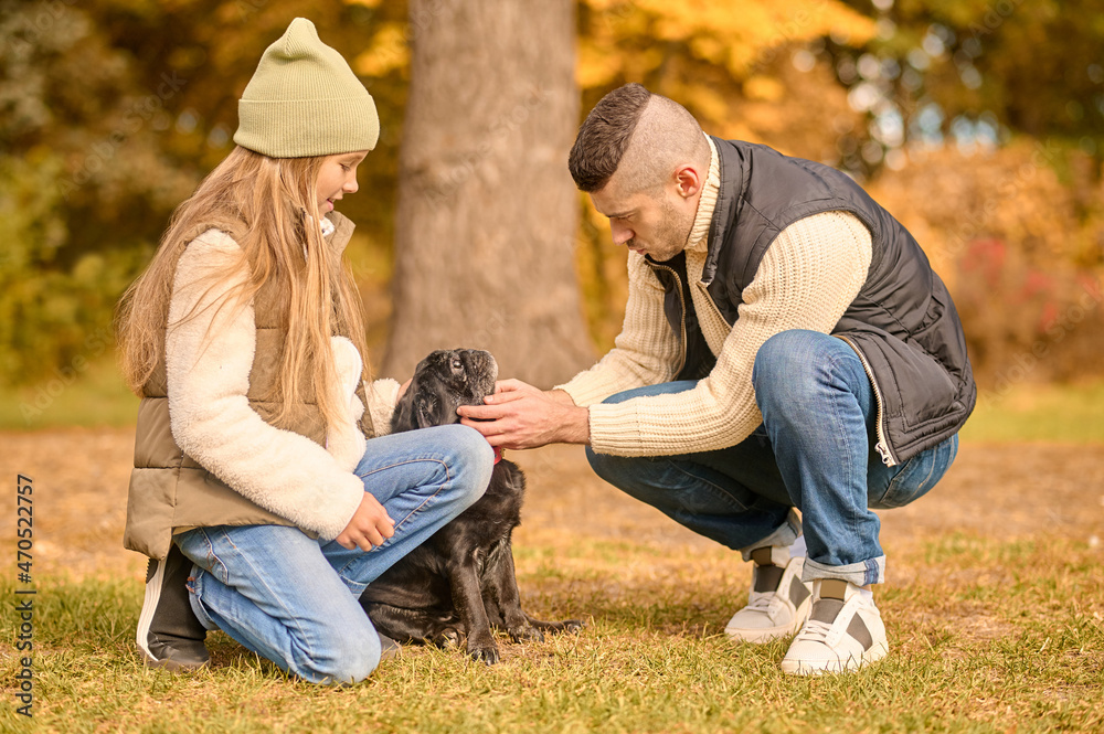 Fototapeta premium A family spending time together in the park with their dog