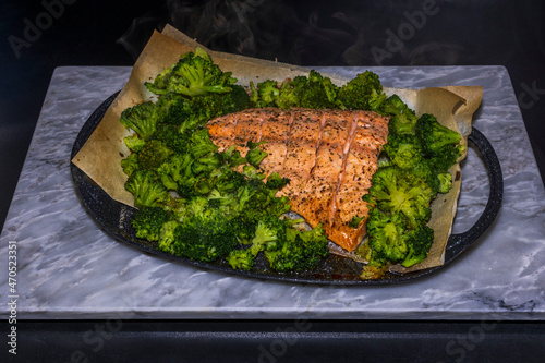 Close up view of pink salmon and broccoli baked in oven. Healthy food concept. Sweden.  photo